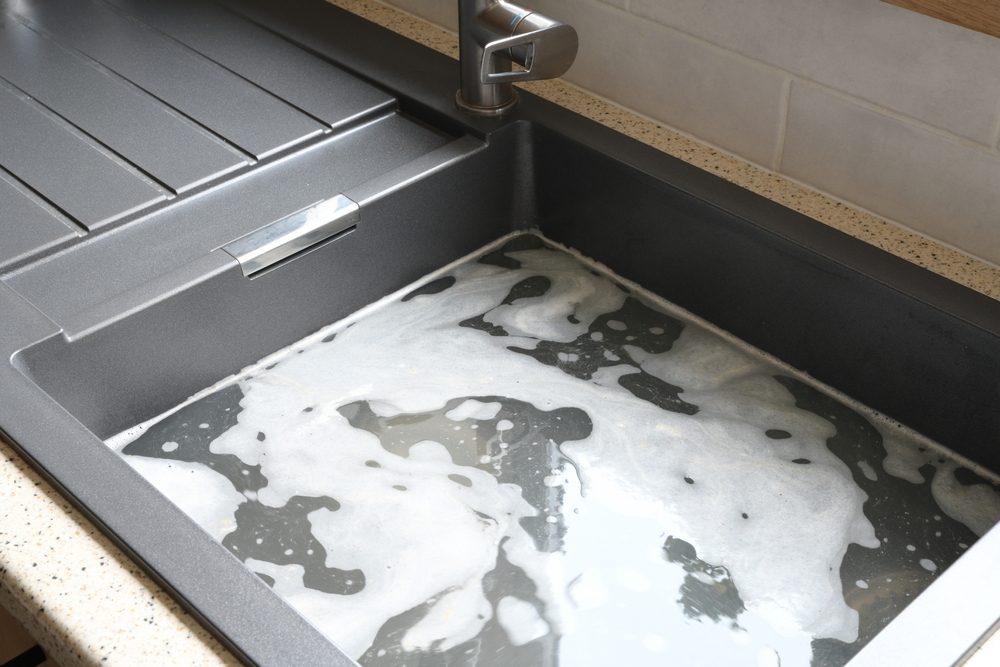 Blocked kitchen sink full of standing water