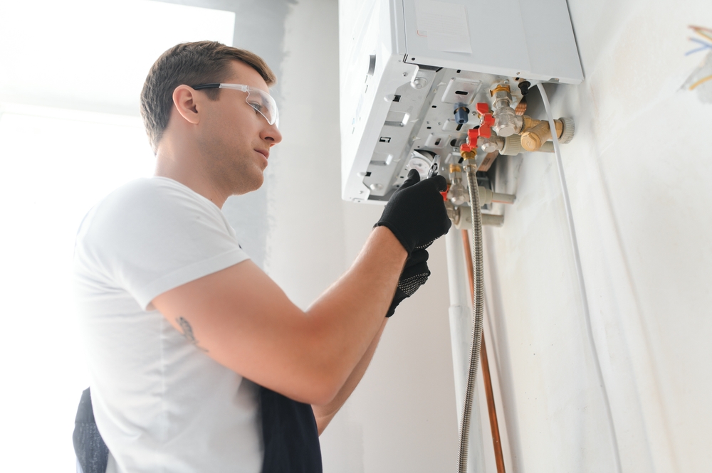 Boiler engineer working on a wall-mounted boiler