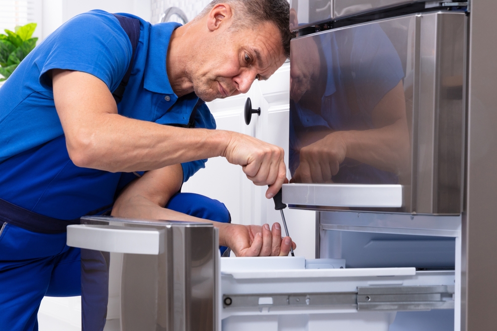 Engineer repairing a fridge freezer