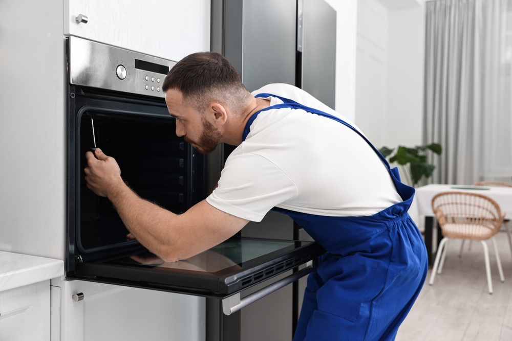 Engineer repairing a built-in oven