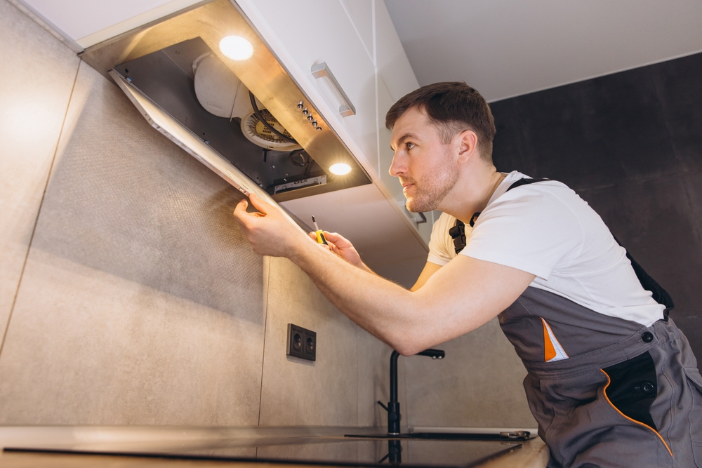 Engineer repairing a kitchen extractor fan
