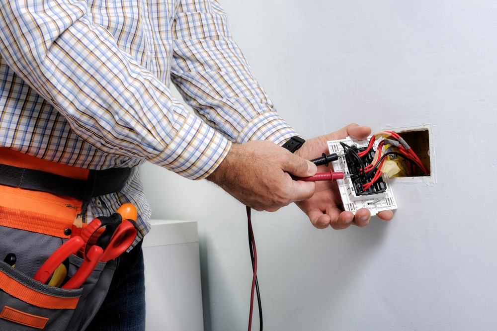 Electrician testing a wall socket