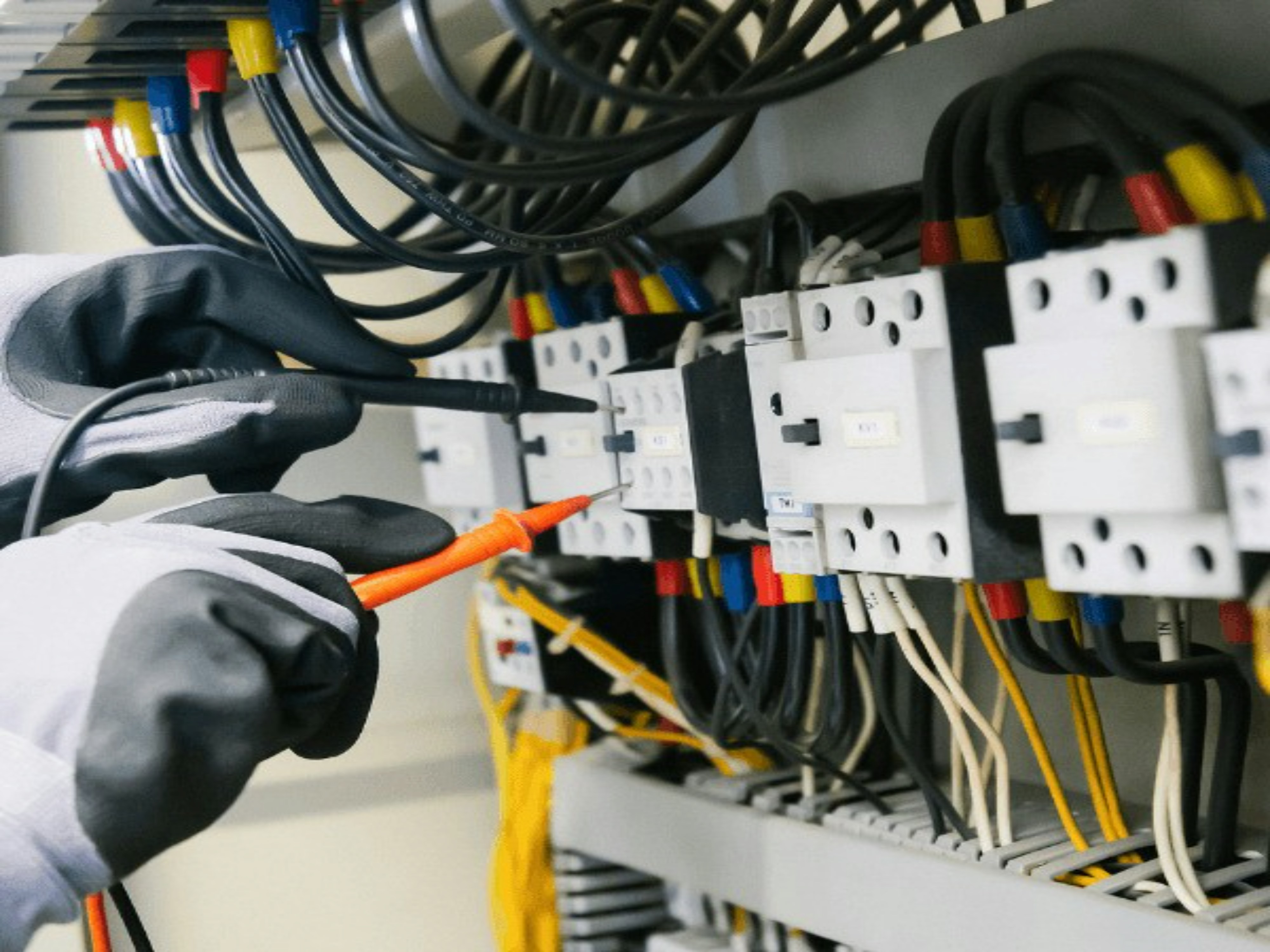 Electrician testing circuits with a multimeter probe